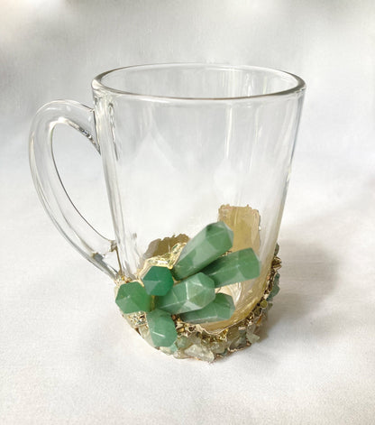 Clear glass mug with green gemstone base on a white background