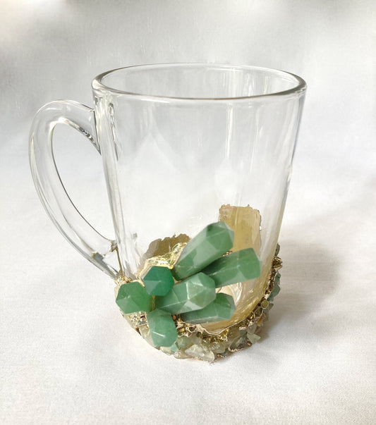 Clear glass mug with green gemstone base on a white background